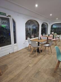 Mesas y sillas en el interior de la cafetería Y Punto